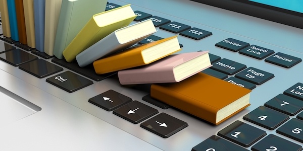 stack of small books on laptop keyboard for marketing independent bookstore