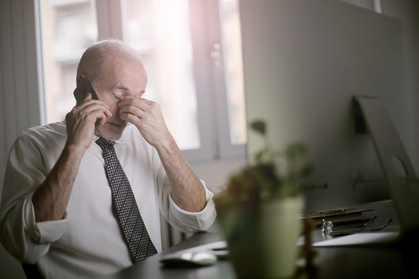 businessman on phone frustrated with how much online reputation management costs