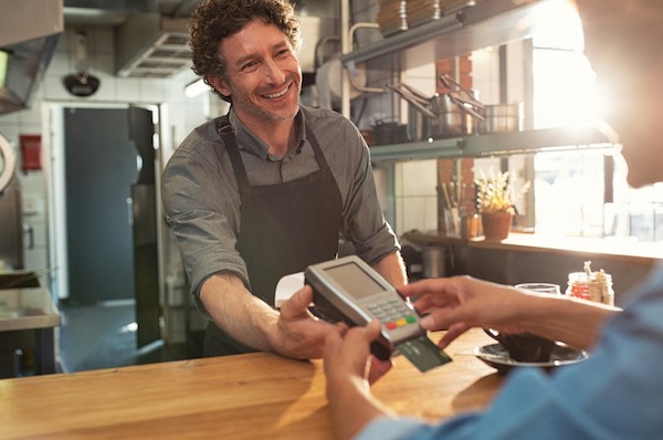 happy cafe owner accepting credit card for loyalty program