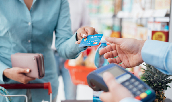 woman handing credit card to grocer for small business CRM