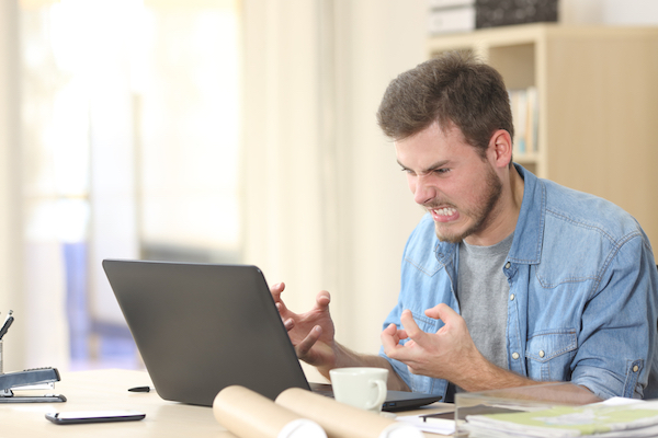 man angry with complicated CRM on laptop