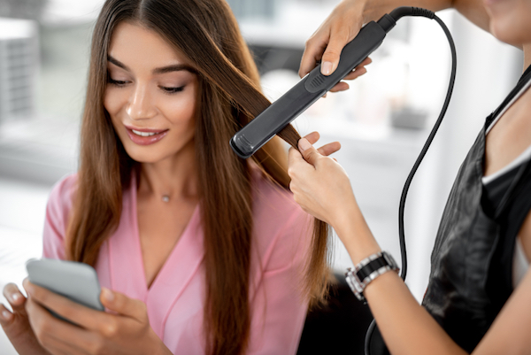 pretty young woman hair straightener for instagram stories marketing
