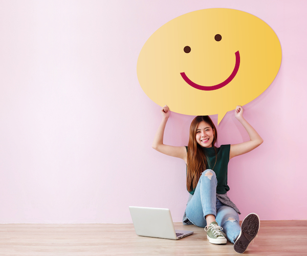 young woman holding a smiley face quote bubble for branding small business