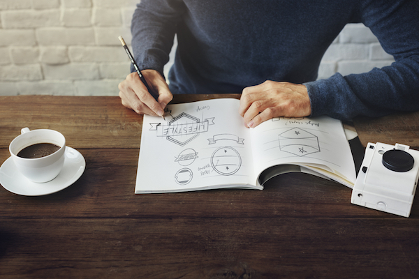 man sketching logo designs for branding small business