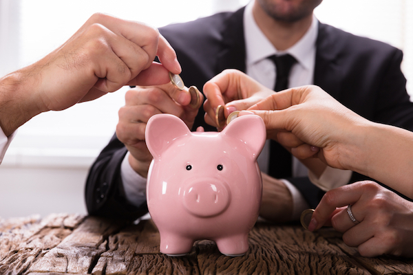piggy bank with people inserting coins for startup crowdfunding