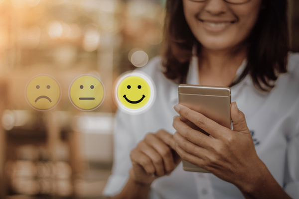 woman pressing virtual emojis during market customer research survey