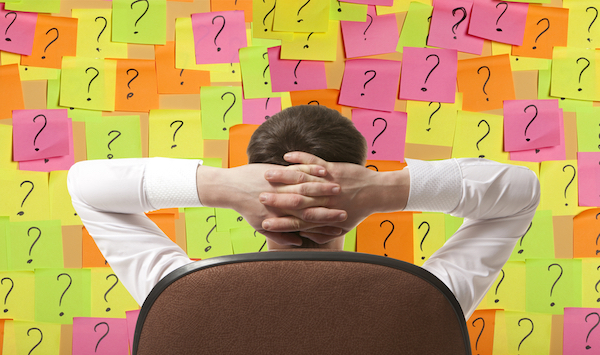 man looking at post-it notes with question marks for small business