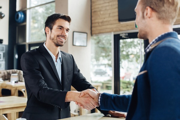 restaurant manager shaking hands with satisfied customer