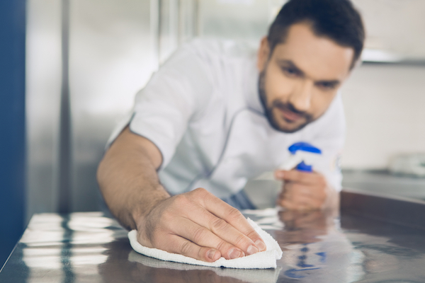 restaurant manager sanitizing surfaces