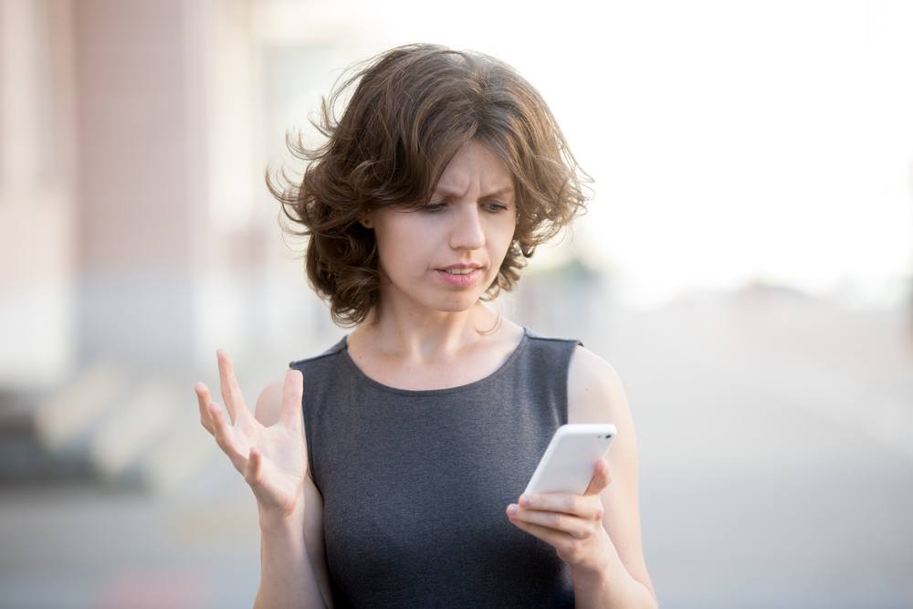 attractive woman confused looking at phone